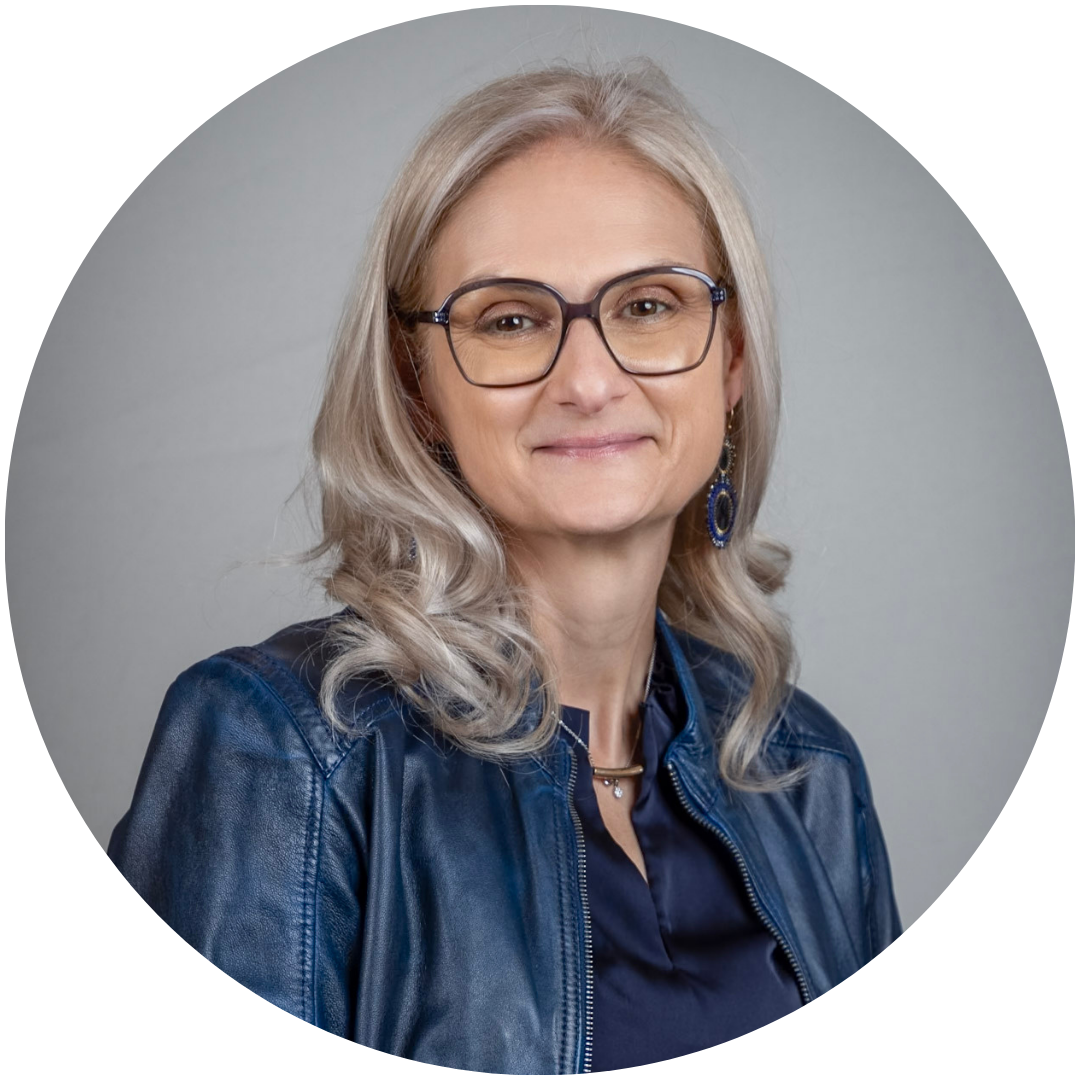 Am Dom-Inhaberin Martina Moser lächelt in die Kamera. Sie trägt eine dunkle Lederjacke und eine dunkle Bluse
